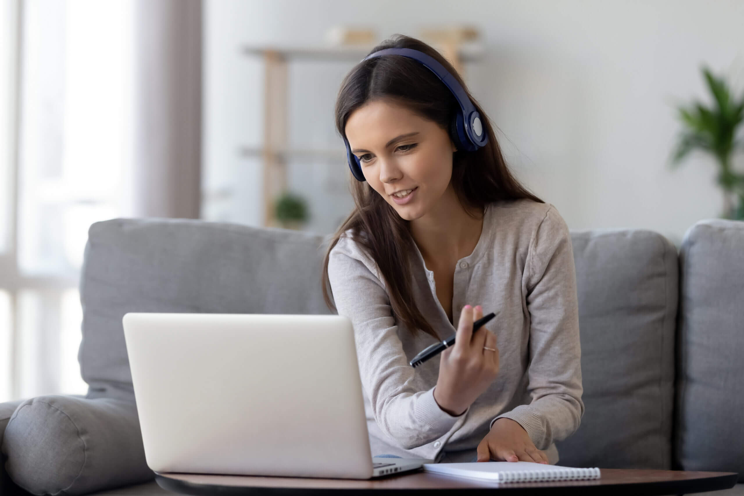 Young woman with headphones studying on laptop